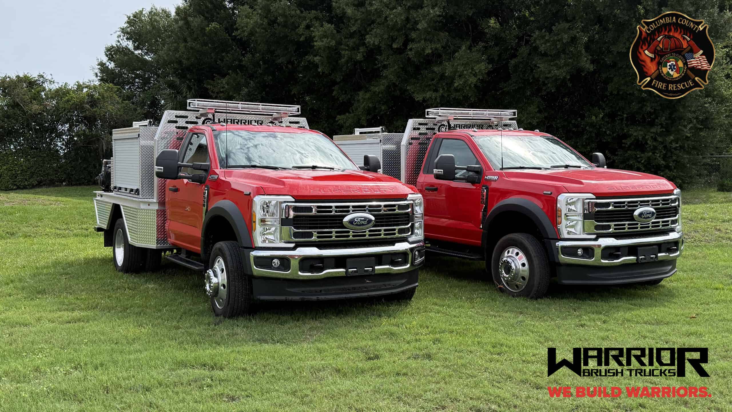 Two red Warrior Brush Trucks parked on a grassy field, designed for wildfire suppression with specialized equipment and durable construction.